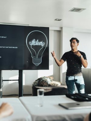 A group attending a modern business presentation with visual ideas on a screen.