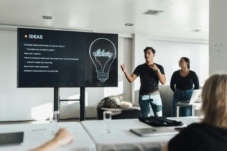 A group attending a modern business presentation with visual ideas on a screen.