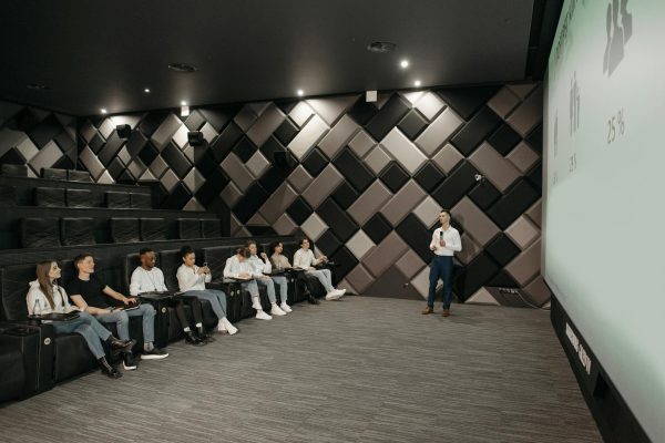 A group attentively listens to a business presentation in a modern, stylish auditorium.